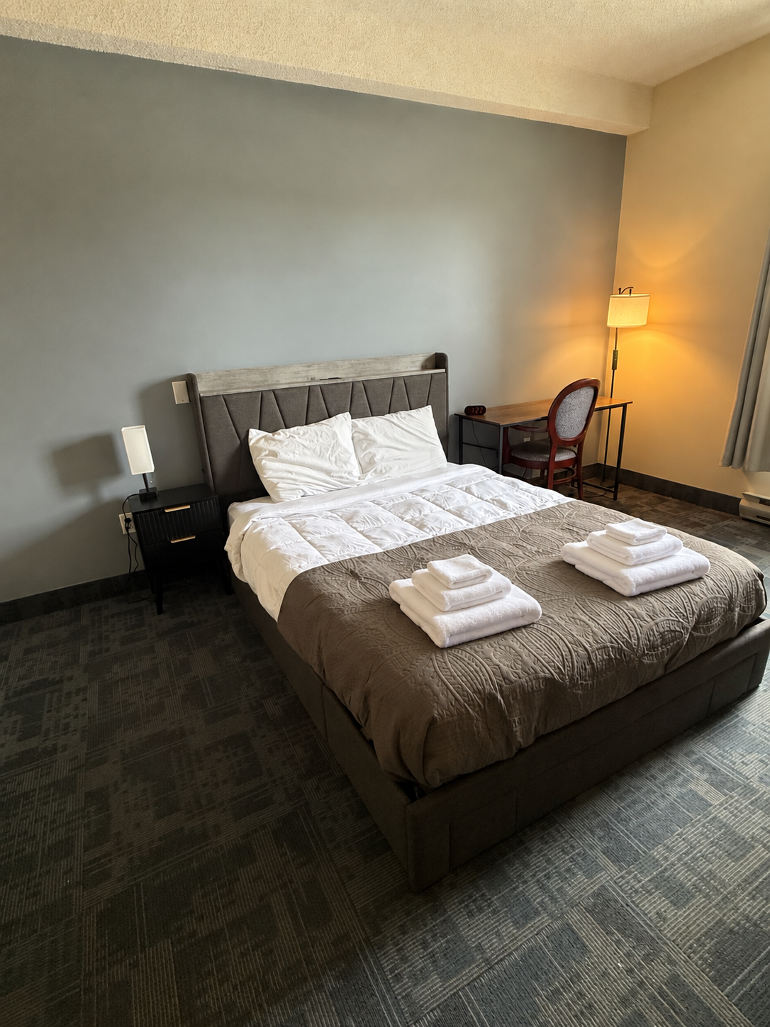 Bedroom with a bed, seating, and television at the Delhi centre