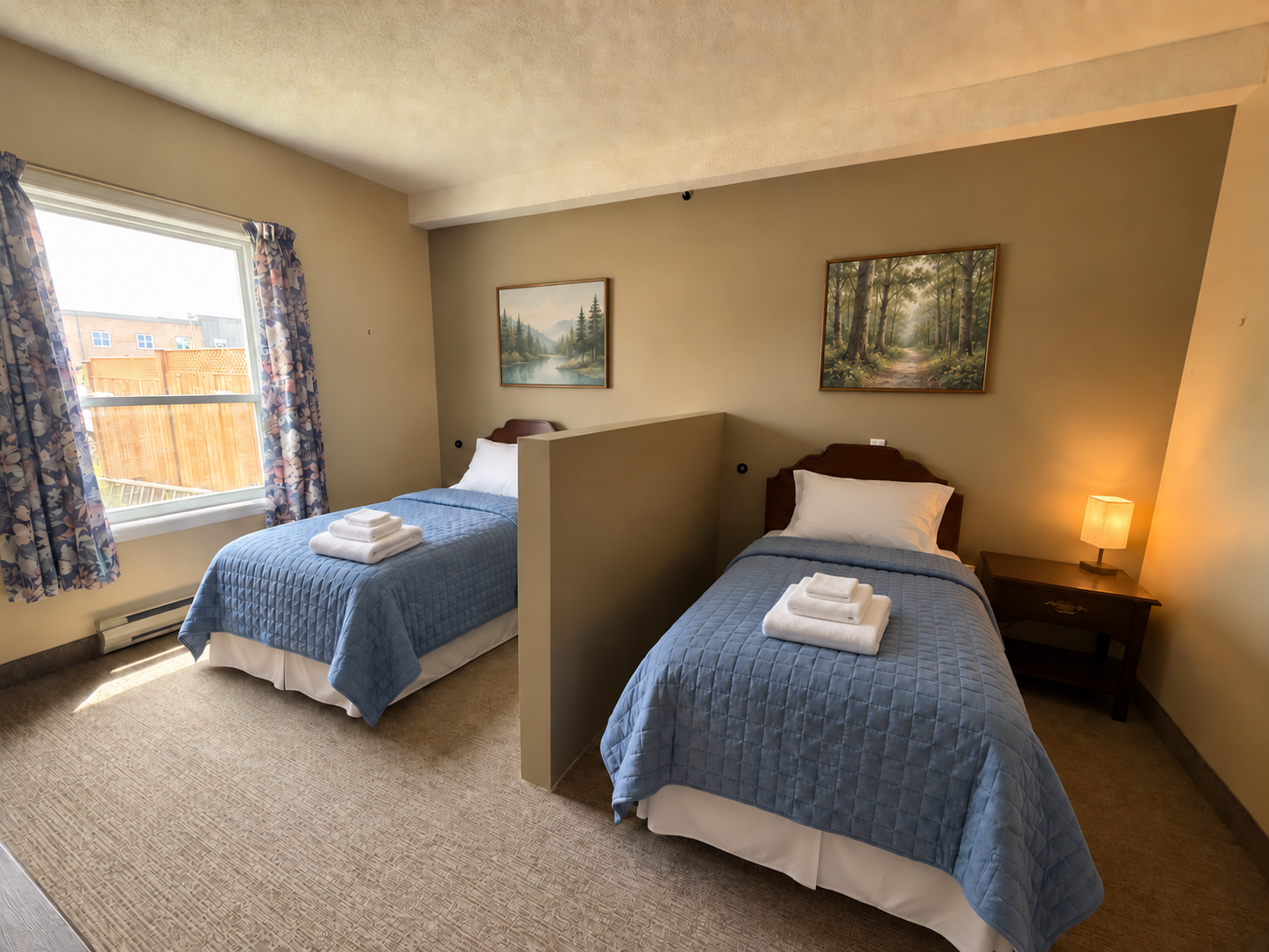 Semi-private room with two beds and a privacy divider; bedding, artwork and towels digitally styled